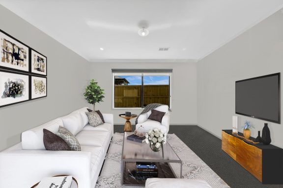 Modern living room with a white sofa, coffee table, and stylish decor. Large window with a view.