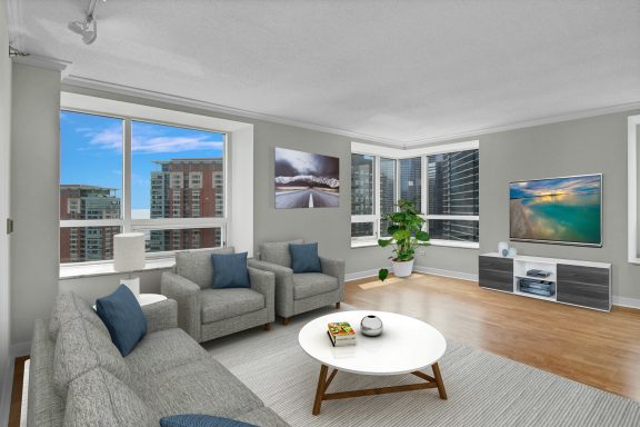 Bright, modern living room with large windows, cozy sofas, and a coffee table.