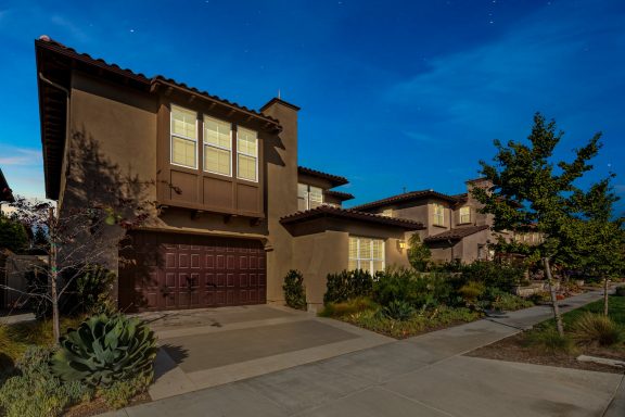 Modern two-story house with landscaping under a twilight sky.